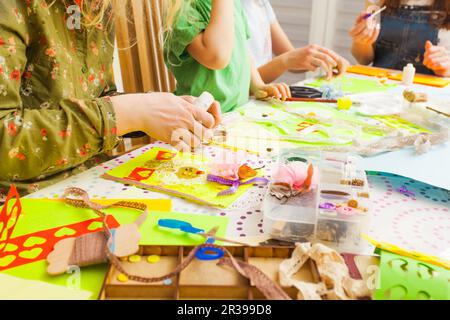 Children's art project, craft for children. Kids doing greeting card at creative workshop with teacher Stock Photo