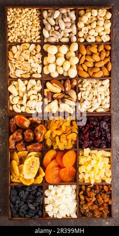 A lot of variety nuts and dried fruits in a wooden box, flat lay, top view Stock Photo