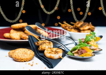 Prawn skewers with clementine salad, prosciutto and parmesan shortbreads Stock Photo