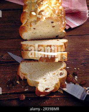 Sliced Bohemian bread with a knife on a wooden background Stock Photo