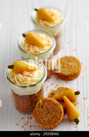 Carrot muffins with cream cheese and marzipan carrots in mason jars for Easter brunch Stock Photo