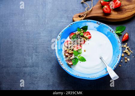 Healthy breakfast served with yogurt, muesli, mint and fresh strawberries Stock Photo