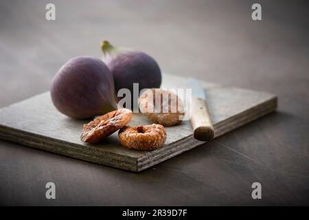 Fresh and dried figs on a wooden board Stock Photo