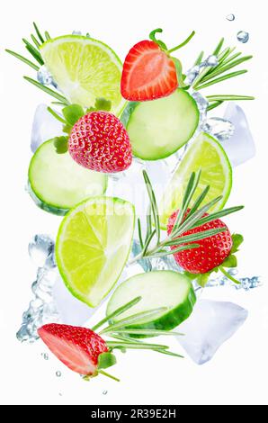Lime, cucumber, strawberry and rosemary flying with ices and water splash Stock Photo