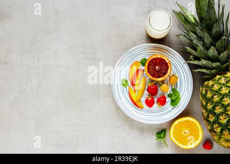 Delicious breakfast with fresh fruit and berries, greek yogurt on light table background Stock Photo