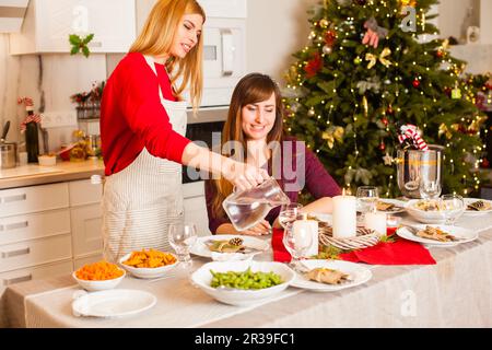 Young woman waiting on her sister at Christmas party Stock Photo