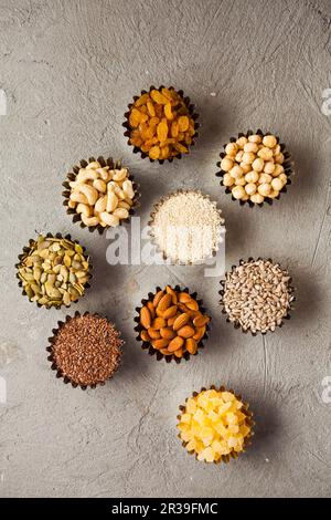 Composition of bowls with healthy dried fruits and tasty nuts on grey background Stock Photo