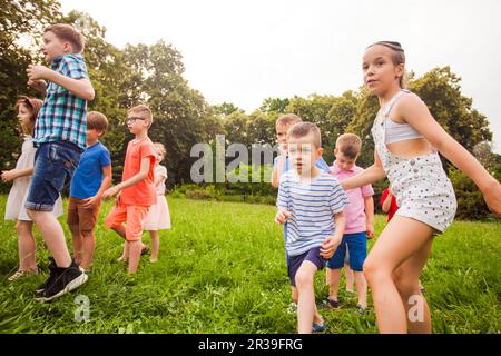 Kids playing funny games in a park in summer time Stock Photo