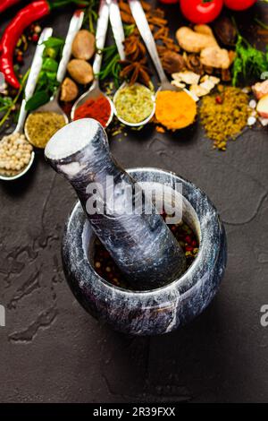 Gray marble mortar on a table with spices and herbs Stock Photo