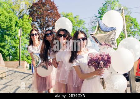 Girls wearing on pink dresses having fun on hen party. Stock Photo