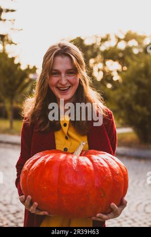 Portrait of beautiful cheerful woman with giant pumpkin Stock Photo