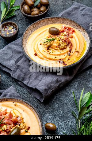 Spanish tomato cold soup Salmorejo served with ham serrano and olives Stock Photo