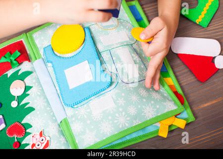 Development fine motor skills with the quiet book Stock Photo