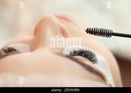Eyelash extension procedure in beauty salon close up Stock Photo
