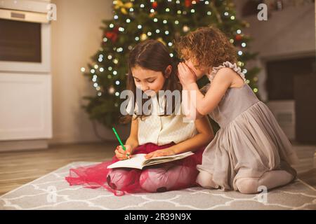 Two girl friends writing a letter to Santa Stock Photo