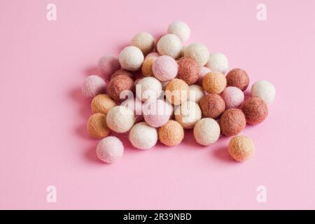 Pale of soft wool balls on pink background Stock Photo