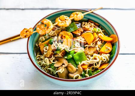 Ramen soup with vegetables, mushrooms, smoked tofu and a prawn skewer Stock Photo