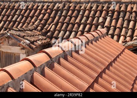 Roof concept with new and old roof tiles Stock Photo