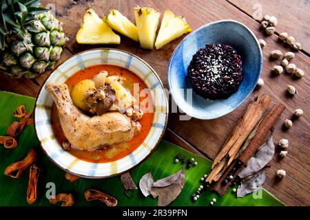 Thai chicken massaman curry served over fluffy and black jasmine rice Stock Photo