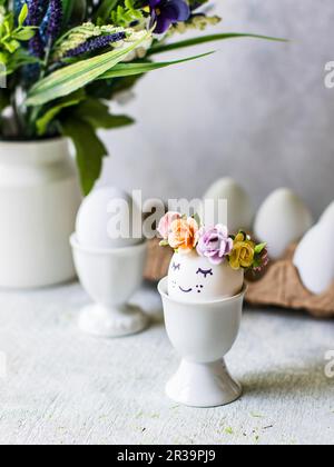 Easter eggs with flower decorations in eggcups Stock Photo