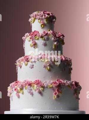 Easter Celebrations, tiered white wedding cake with tumbling sugared flowers Stock Photo