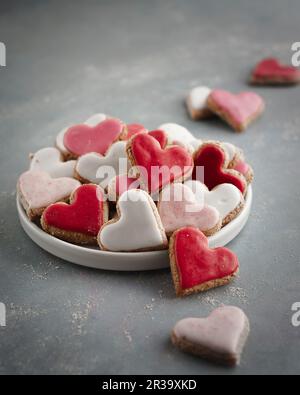 Pink, red and white heart-shaped biscuits on a plate Stock Photo