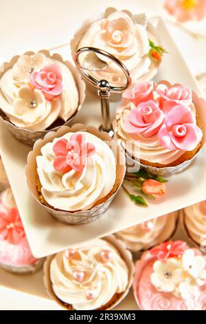 Festive cupcakes decorated with cream topping and sugar flowers Stock Photo