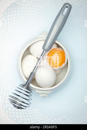 Eggs and a whisk Stock Photo