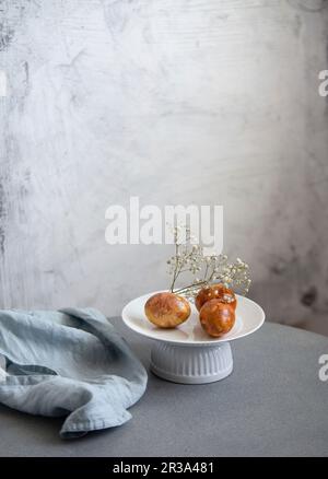 Easter Eggs, Naturally Dyed with Onion Skins, Flowers and Herbs on marble background Stock Photo