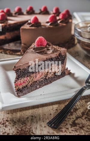 Slice of chocolate raspberry mousse cake on square white plate Stock Photo