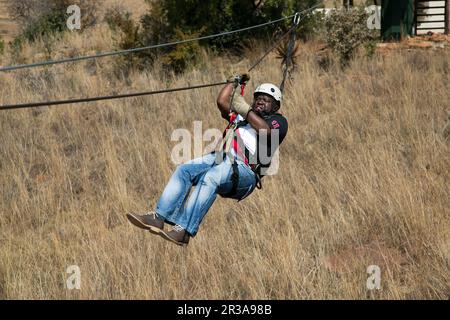 Diverse Adults having fun on a Zip Line ride in the countryside Stock Photo