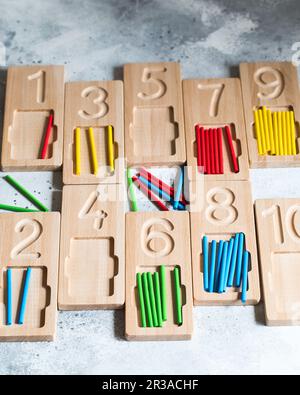 Wooden counting and writing trays with colored counting sticks. Montessori materials. Counting math Stock Photo