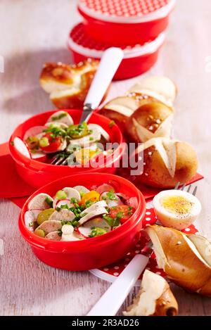 White sausage salad with lye bread rolls in plastic containers to take away Stock Photo