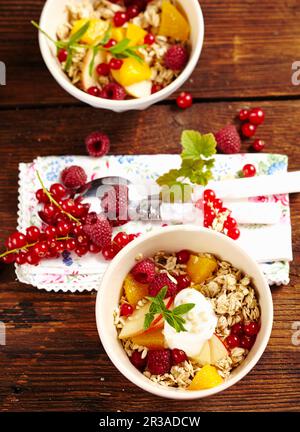 Bircher muesli with oats, fresh berries, apples, orange, milk, honey, yoghurt and almonds Stock Photo