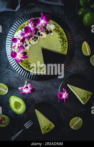 Avocado and lime cheesecake decorated with flowers and pistachios Stock Photo