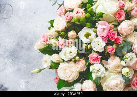 Bouquet of beautiful flowers with peonies, roses and eustomas in the papper gift box in front of gre Stock Photo