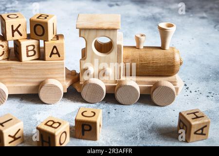 Children's wooden toys. Children wooden train with wagons. Natural wood construction set. Educationa Stock Photo