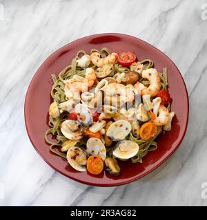 Mediteranian seafood, white wine, shrimp, mussels, clams, calamari, tomatoes in plate on white Stock Photo