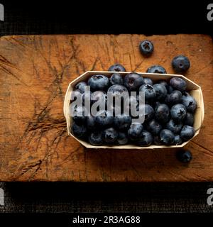 Blueberries in wooden tray on cutting board Stock Photo