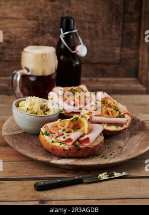 Rolls topped with Leberkäse (beef and pork meatloaf) and chive, onion and mustard butter Stock Photo
