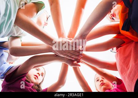 Little children putting their hands together outdoors, view from down. Stock Photo