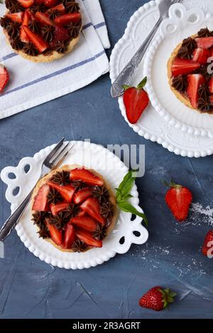 Mini tart with strawberry jam, served with fresh strawberries and chocolate ganache Stock Photo