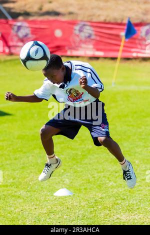 Diverse children playing soccer football at school Stock Photo