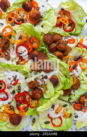 Lettuce with lentil balls and yoghurt dressing Stock Photo
