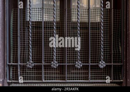 Metal wrought iron fence of a window at street level Stock Photo