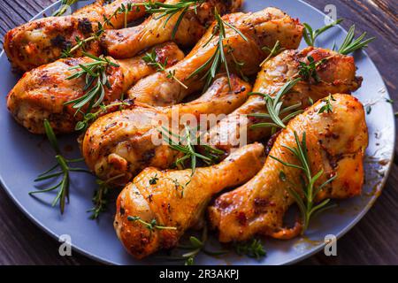 Grilled chicken drumsticks on dark plate, top view Stock Photo