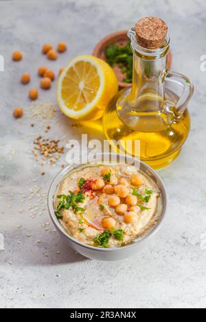 Chickpea hummus with olive oil and lemon on light background Stock Photo