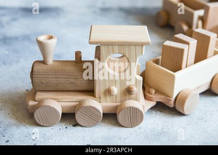 Children's wooden toys. Children wooden train with wagons. Natural wood construction set. Educationa Stock Photo
