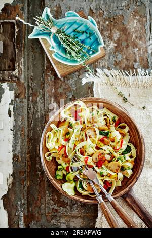 Tagliatelle with chilli, mushrooms, courgettes, olive oil and thyme Stock Photo