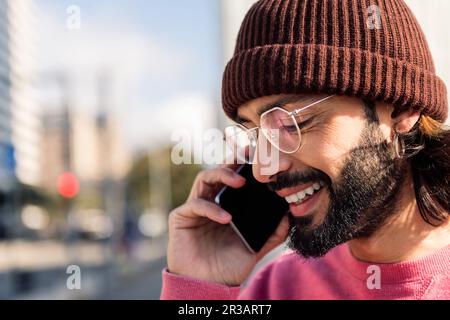 stylish man smiling happy talking on smart phone Stock Photo